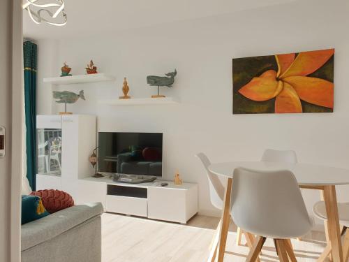 uma sala de estar branca com uma mesa e uma televisão em Mirando al Mar desde el Rihuete em Puerto de Mazarrón