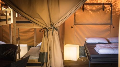 Pokój z 2 łóżkami piętrowymi i lampką w obiekcie Safari Tent XL Camping Belle-Vue w mieście Berdorf