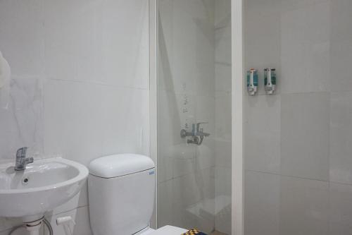 a bathroom with a toilet and a sink and a shower at RedDoorz Syariah @ Raya Punten Batu in Punten