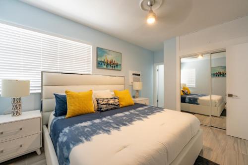 een slaapkamer met een groot bed met gele en blauwe kussens bij The Surf Hollywood Beach in Hollywood