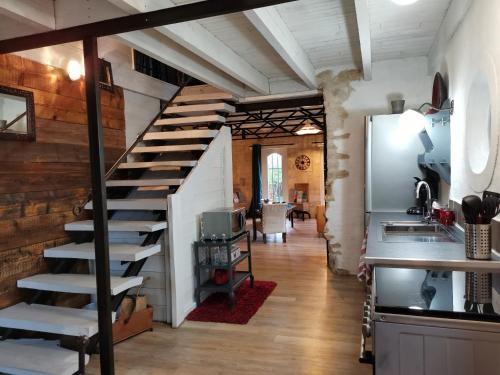 een wenteltrap in een kamer met een keuken bij Warm 2 bedroom stone house with garden - Dodo et Tartine in Saint-Sigismond
