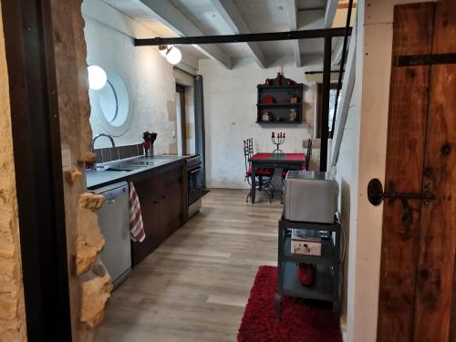 a kitchen with a sink and a stove at Warm 2 bedroom stone house with garden - Dodo et Tartine in Saint-Sigismond
