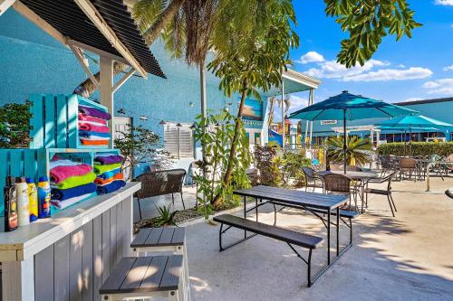 un patio con mesas, sillas y sombrillas en Malibu Resort Motel, en St Pete Beach