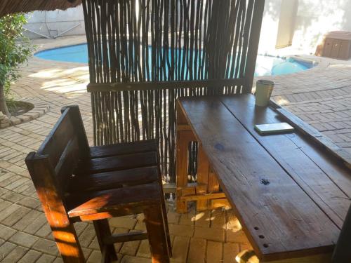a wooden table and chair with a cup of coffee on it at SapzRes at Klerksdorp in Klerksdorp
