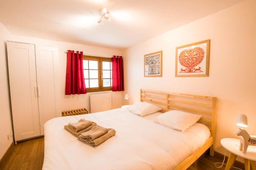 a bedroom with a large white bed with red curtains at Le Bois des Neiges Charmant chalet authentique à 5 mn de Gérardmer in Xonrupt-Longemer