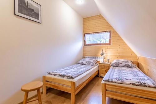 1 dormitorio con 2 camas, escritorio y ventana en Stara Chata, en Zakopane