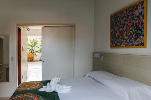 a bed with a stuffed animal sitting on top of it at Jardim Atlântico Beach Resort in Ilhéus