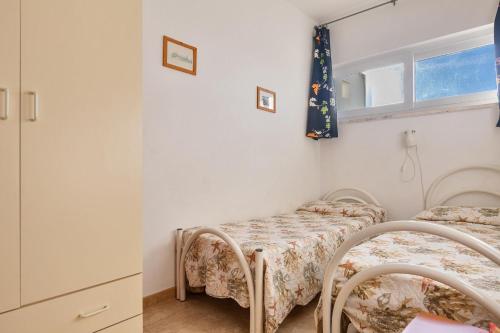 a room with two beds and a window at Appartamento Cristallo by BarbarHouse in Torre Lapillo