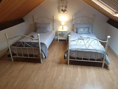 two twin beds in a room with a attic at Les Gages in Brécé
