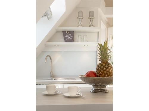 a kitchen with a sink and a bowl of fruit at Ferienwohnung - Tessa in Tinnum