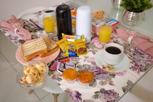 einen Frühstückstisch mit Frühstückszutaten und einer Tasse Kaffee in der Unterkunft Motel Sedución (Adults only) in Cascavel