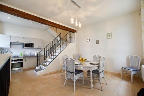 une cuisine et une salle à manger avec une table et des chaises dans l'établissement L'Oustau - ruelle bucolique, à Arles
