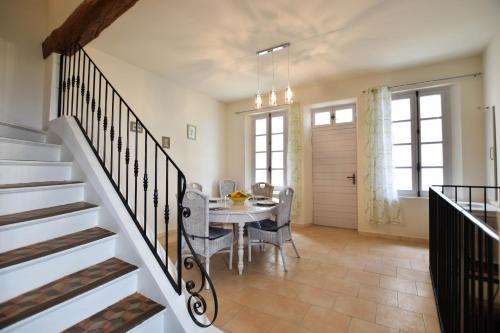 een keuken en eetkamer met een tafel en een trap bij L'Oustau - ruelle bucolique in Arles