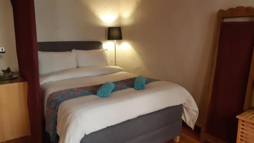 um quarto de hotel com uma cama com chinelos azuis em À Deux Pas ... em Briançon