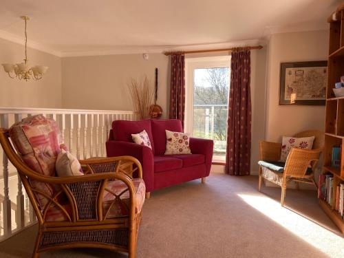a living room with a red couch and a window at Millbrook in Penistone