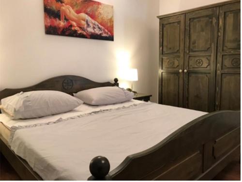 1 cama con 2 almohadas y una pintura en la pared en Apartments Anita, en Cavtat