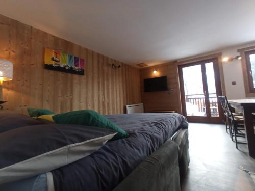 a bedroom with two beds and a table and a television at La Chaine du Mont-blanc in Chamonix-Mont-Blanc