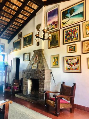 a living room with a stone fireplace and pictures on the wall at Hosteria Fortin de San Miguel in Chuy