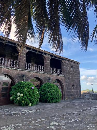 a brick building with two bushes in front of it at Hosteria Fortin de San Miguel in Chuy