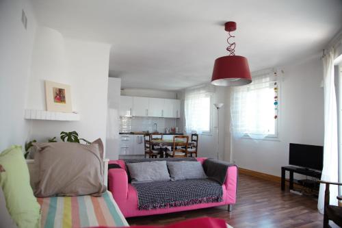 sala de estar con sofá rosa y cocina en Laincel - Clim - Balcon, en Arles