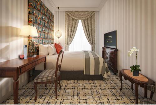 ショプロンにあるPannonia 1893 Prémiumのベッドとデスクが備わるホテルルームです。