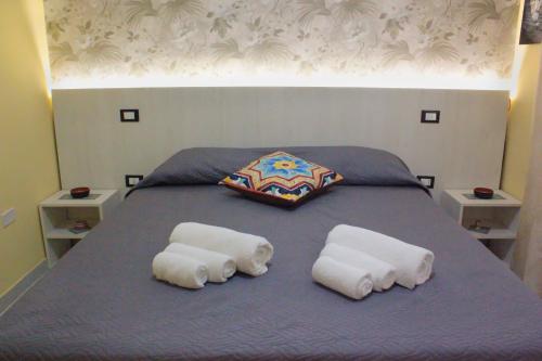 a bed with two rolled towels on top of it at Villa Rosanna in Sciacca