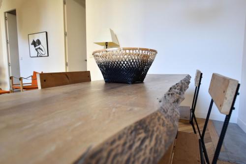 - une table en bois dans le salon avec une lampe dans l'établissement St Honoré - Appart Design, à Arles