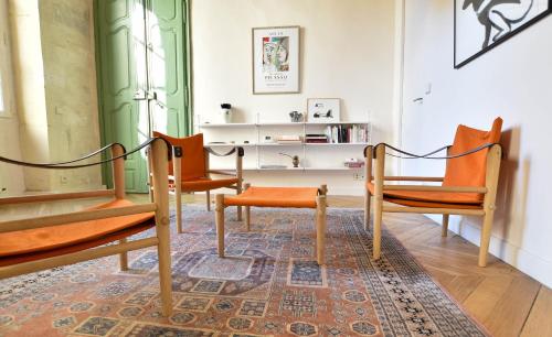 une chambre avec deux chaises orange et un tapis dans l'établissement St Honoré - Appart Design, à Arles