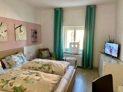 アルノルトシュタインにあるB&B Leonhard 7のベッドルーム1室(ベッド2台付)、緑のカーテン付きの窓が備わります。