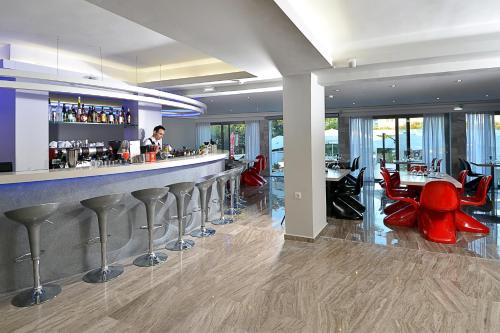 a bar in a restaurant with red stools at TRYP by Wyndham Corfu Dassia in Dassia