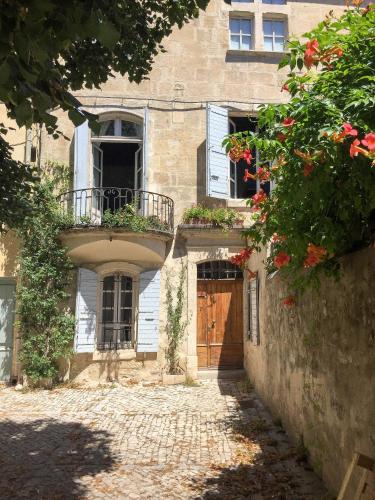 - un ancien bâtiment avec une porte et un balcon dans l'établissement Zen Arena, Clim - Terrasse, à Arles