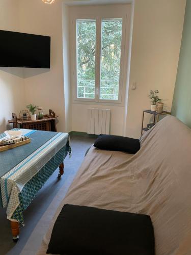 a bedroom with two beds and a large window at appartement à Tarascon sur Ariège le Sabart in Tarascon-sur-Ariège
