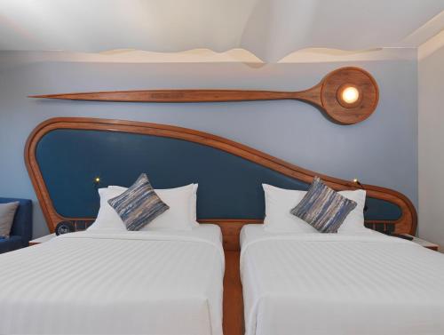 two beds in a room with white sheets at The Oceanic Sportel Phuket - SHA Extra Plus in Phuket Town