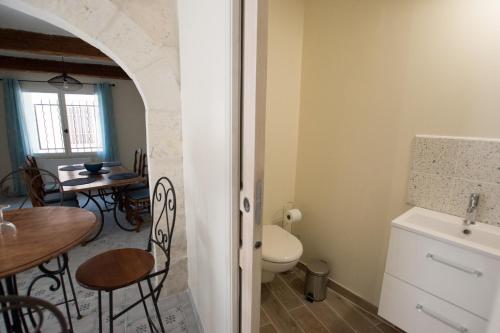 baño con mesa y aseo y cocina en Madeleine - Maison proche des Arènes, en Arles