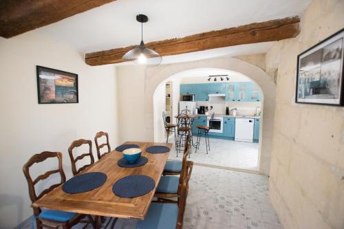 cocina y comedor con mesa de madera y sillas en Madeleine - Maison proche des Arènes en Arlés