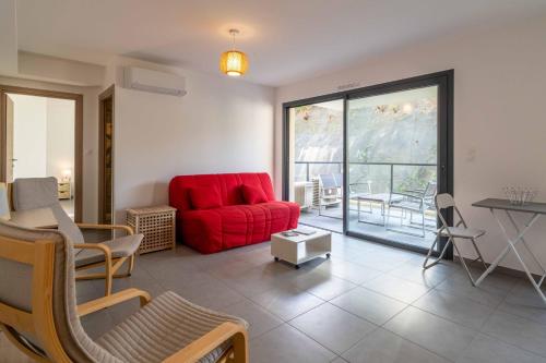 un salon avec un canapé rouge et une table dans l'établissement Fronte di Mare - deux pièces en bord de mer, à Propriano