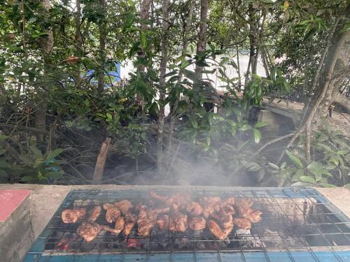 a bunch of chickens cooking on a grill at CabinStay Cikgu Sungai Batu Besi in Sungai Petani