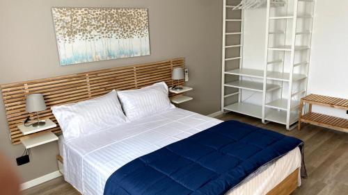 a bedroom with a blue and white bed and shelves at Foresteria Green House 1 in Seriate