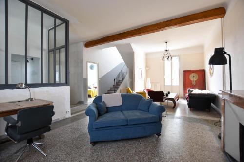 un salon avec une chaise bleue et une table dans l'établissement Palmeira, Piscine - Parking - Clim, à Arles