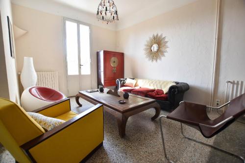 ein Wohnzimmer mit Sofa und Tisch in der Unterkunft Palmeira, Piscine - Parking - Clim in Arles