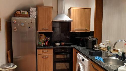a kitchen with a stainless steel refrigerator and a sink at House of Bondol in Aberdeen