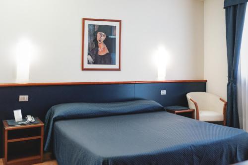 Un dormitorio con una cama azul y una foto en la pared en Hotel Crystal, en Preganziol