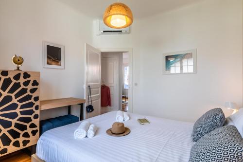 a bedroom with a bed with a hat on it at Superbe appartement plein de charme à 5min de la plage in Biarritz