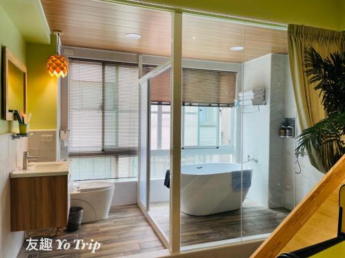 a large bathroom with a tub and a window at Yo Trip in Tainan