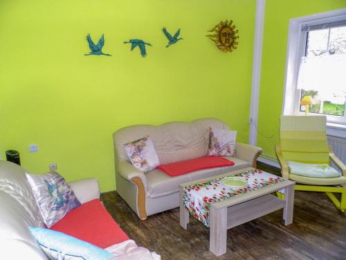 a living room with a couch and birds on the wall at Ferienwohnung Gluehwuermchen in Barnin