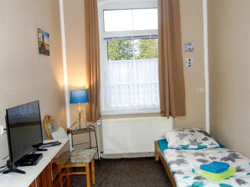 a bedroom with a bed and a desk and a window at Ferienwohnung Gluehwuermchen in Barnin