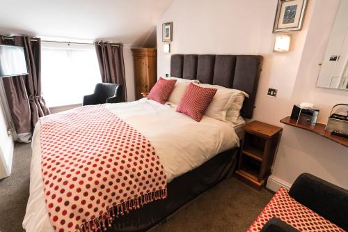 a bedroom with a large bed with red pillows at The Helaina in Scarborough