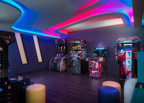 a gaming room with arcade machines and neon lights at The Oceanic Sportel Phuket - SHA Extra Plus in Phuket Town