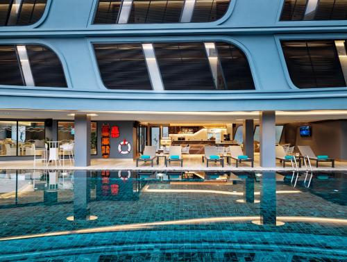 a building with a swimming pool in front of it at The Oceanic Sportel Phuket - SHA Extra Plus in Phuket Town