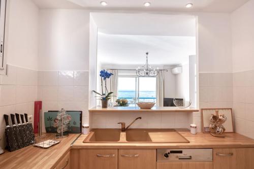 une cuisine avec un évier et une fenêtre dans l'établissement Horizon Blue Lux Apartment, à Nice